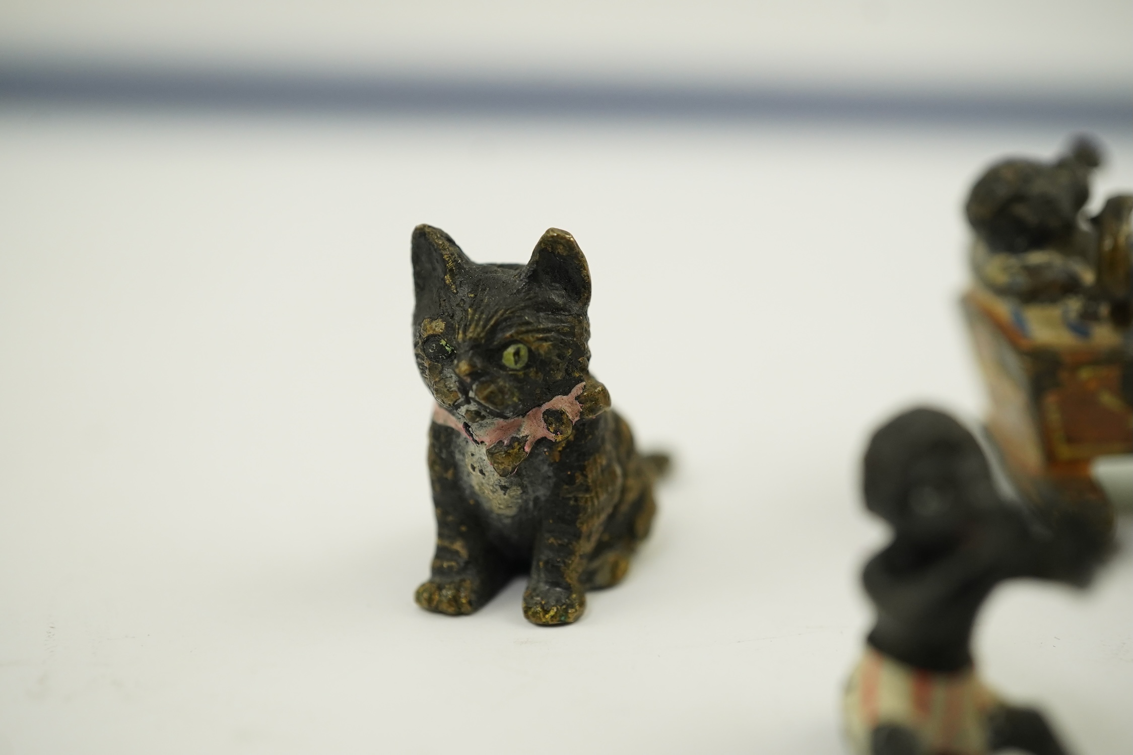 Four novelty miniature cold painted bronzes; black boy with cradle, black baby, cat and pig and a similar articulated arm skeleton stickpin,7cm long. Condition - some chipping to paint